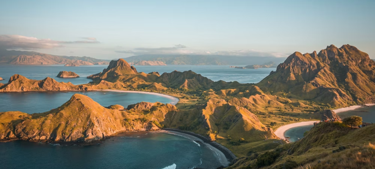 brown mountain beside body of water during daytime