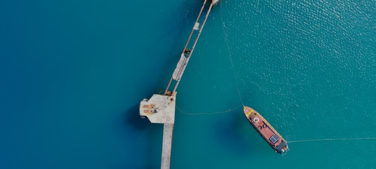 aerial photography of boat approaching bridge
